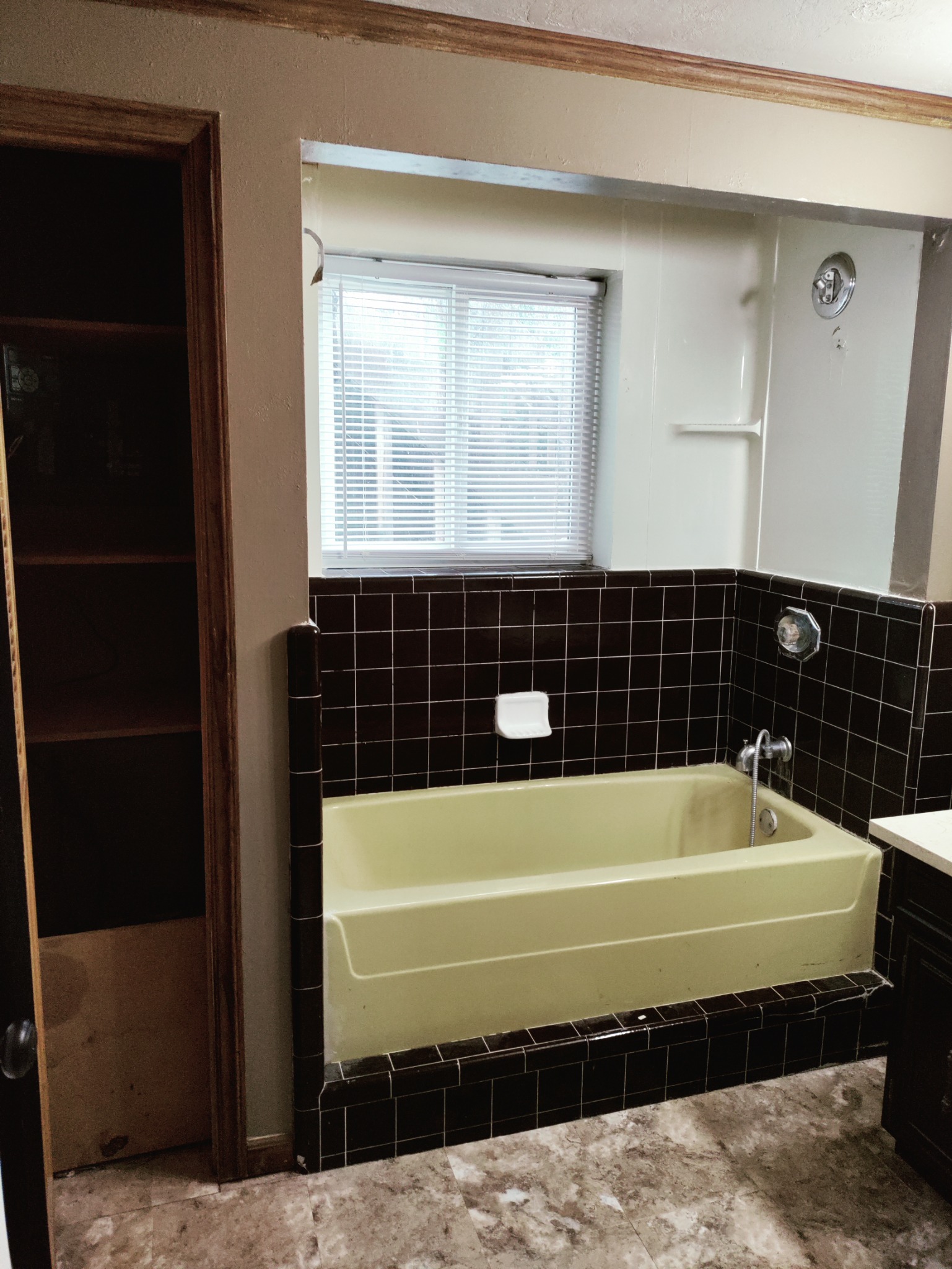 Outdated yellow bathtub before tub to shower conversion in Utah bathroom remodel