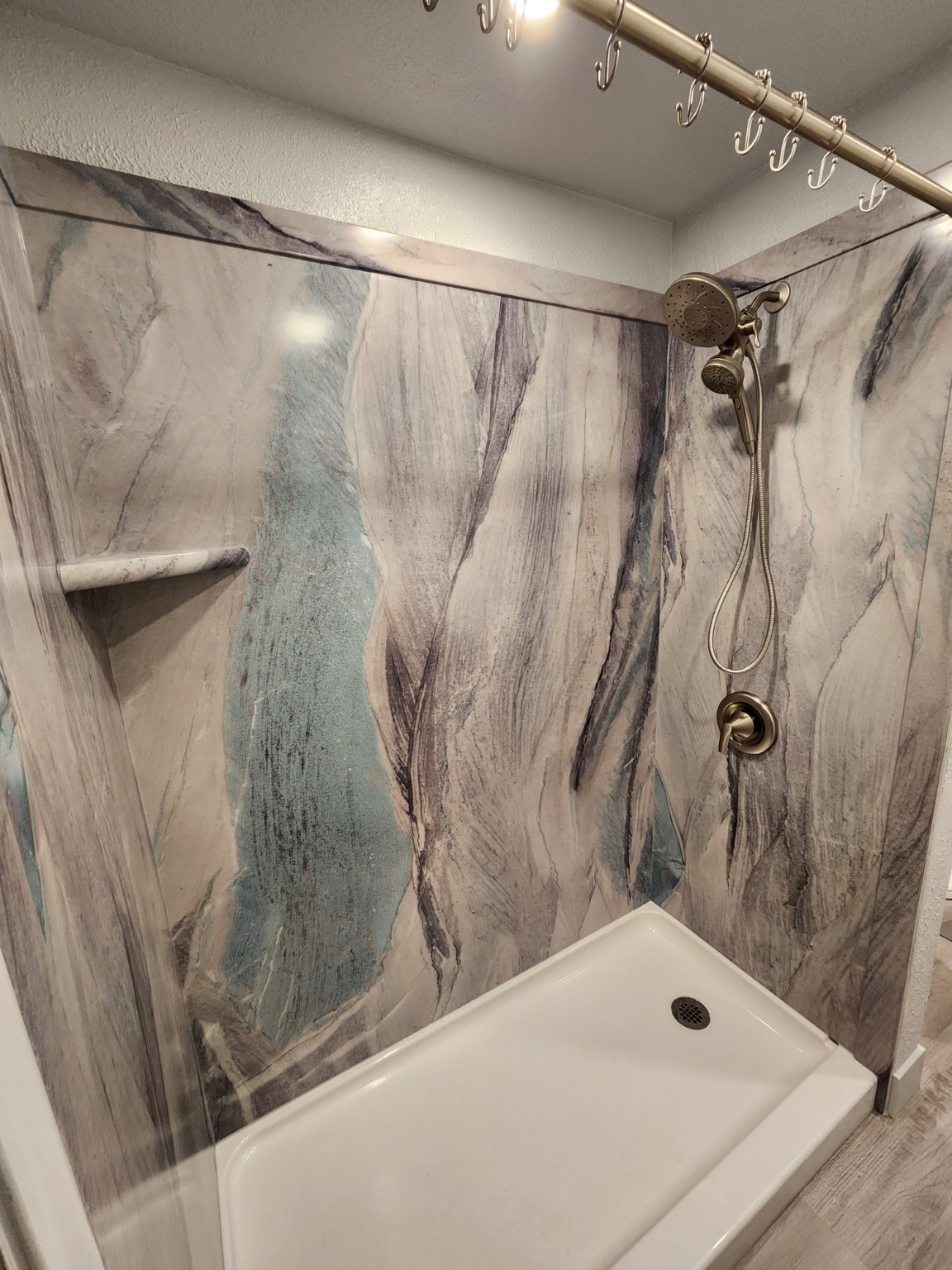 Bathroom after Sentrel shower wall panel conversion with stone-look panels
