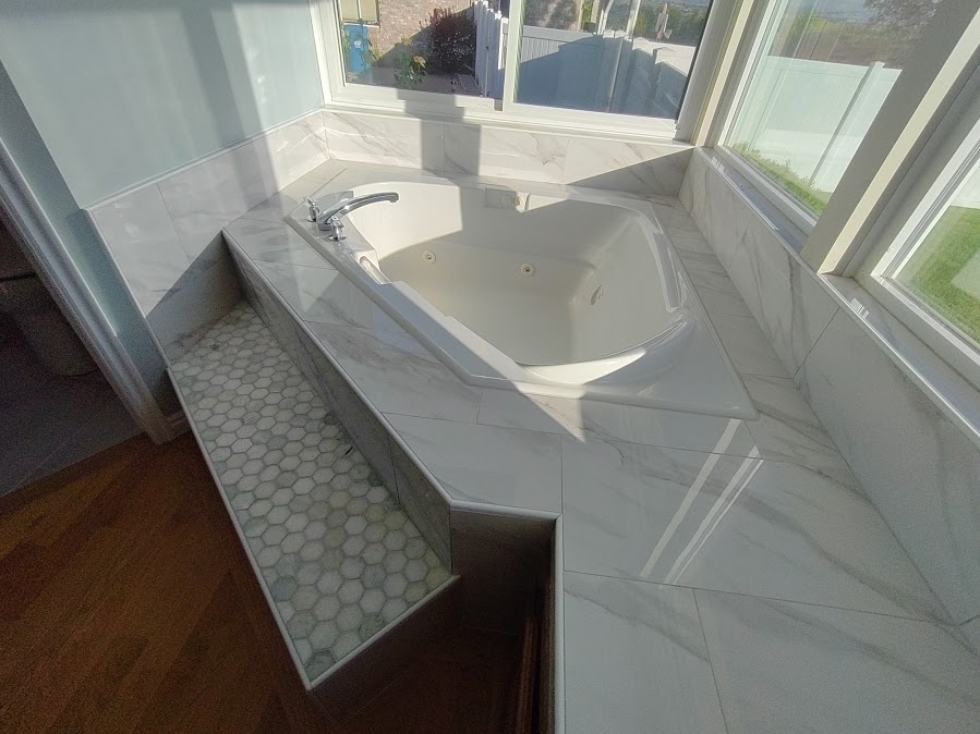 Finished jetted tub surround remodel with tile and natural light