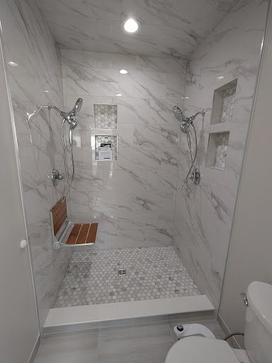 Custom tile shower with marble walls and bench